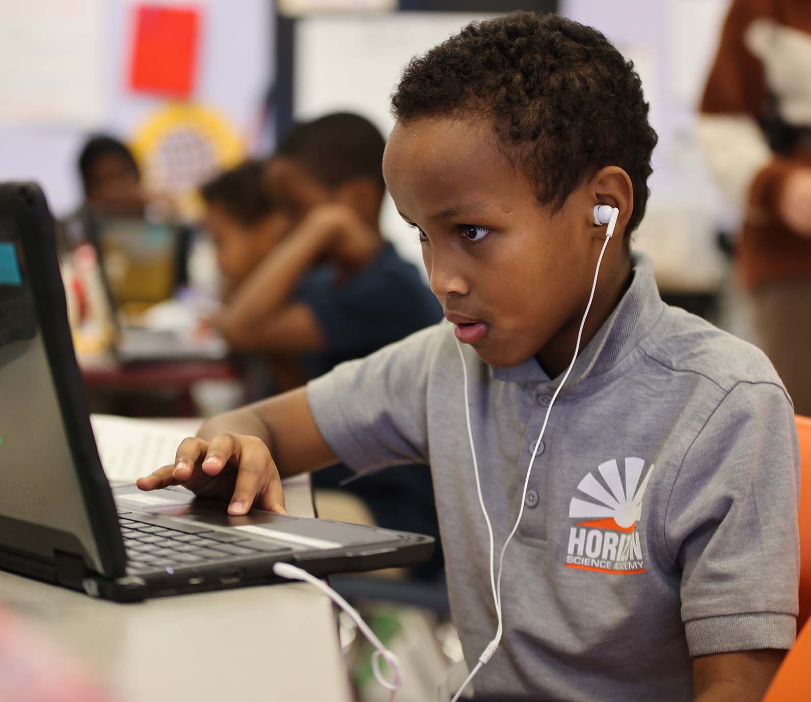 Horizon Science Academy Columbus Elementary student wearing headphones uses a laptop in class