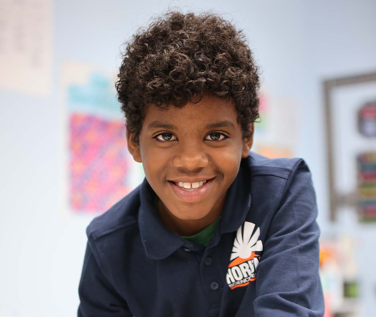 Student working on a notebook in a classroom.